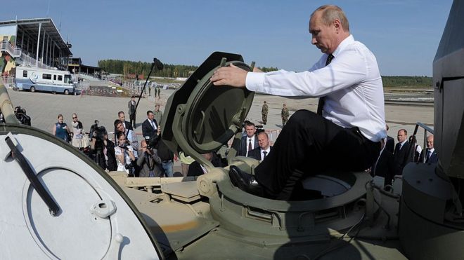 Russia's Prime Minister Vladimir Putin gets into a T-90AM tank