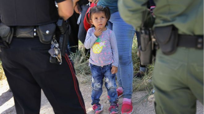 Niña inmigrante mira a agentes de la Patrulla Fronteriza en Texas.