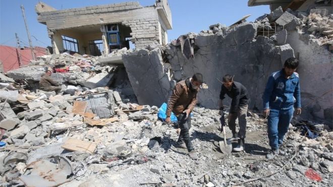 Iraqis clean up in rubble from air strike (file photo)
