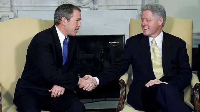 Президент Билл Клинтон (справа) и избранный президент Джордж Буш (слева) пожимают друг другу руки во время встречи в Белом доме.