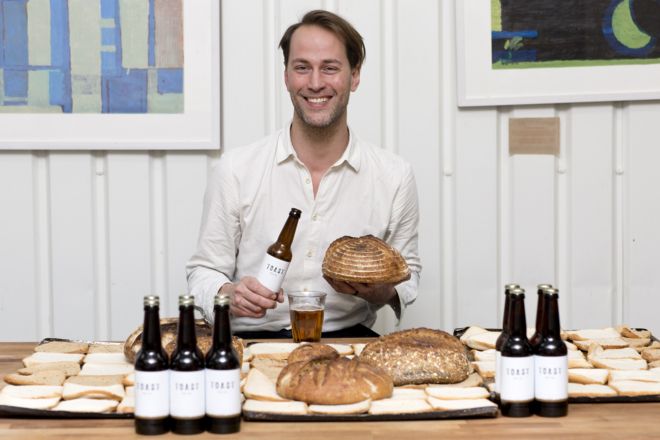 Основатель тоста Тристрам Стюарт сидит в окружении хлеба и тостового пива