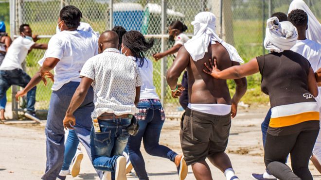 Haitian migrants try to return to the airplane used by U.S. authorities to fly them out of a Texas border city after crossing the Rio Grande river from Mexico, at Toussaint Louverture International Airport in Port-au-Prince, Haiti September 21, 2021.
