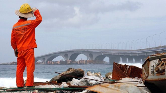 Строитель наблюдает, как финансируемый Китаем мост Синамале виден в Мале, Мальдивы, 18 сентября 2018 года.