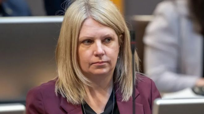 Hannah Blythyn, with blonde hair and burgandy suit jacket,  sat in the Senedd frowning