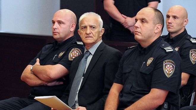 Dragan Vasiljkov sits flanked by policemen