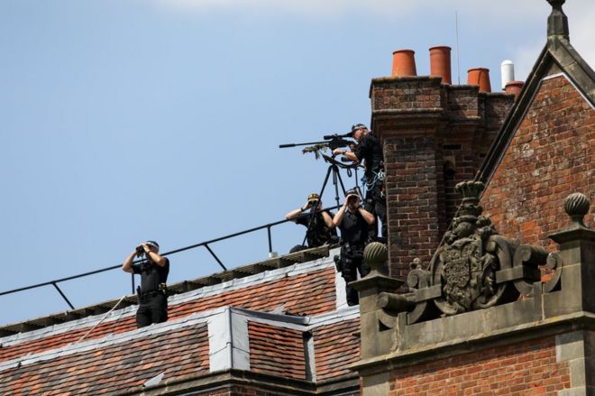 Вооруженные офицеры британской полиции смотрят с крыши шашки перед совместной пресс-конференцией