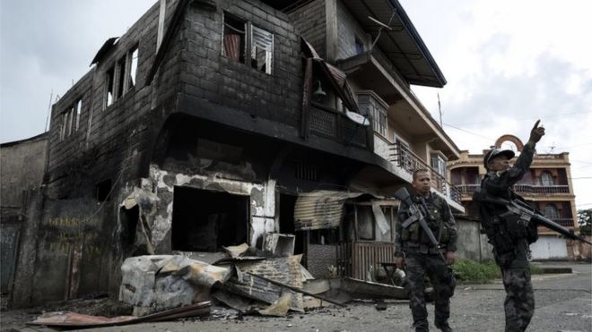 Полиция осматривает поврежденные здания в Марави, Минданао. Фото: 29 мая 2017 г.