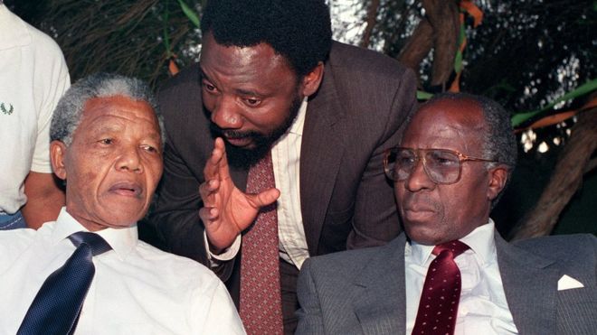 Nelson Mandela (L) and Andrew Mlangeni (R) listen to Cyril Ramaphosa