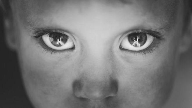 Los ojos de un niño con la cara sucia