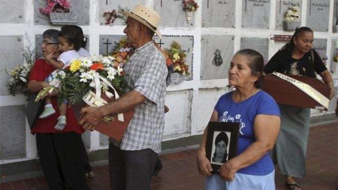 На кладбище Сан-Педро в Медельине 25 февраля 2011 года Леонель де Хесус Варгас несет небольшой гроб с останками своей дочери Глории, сопровождаемый его женой Розой