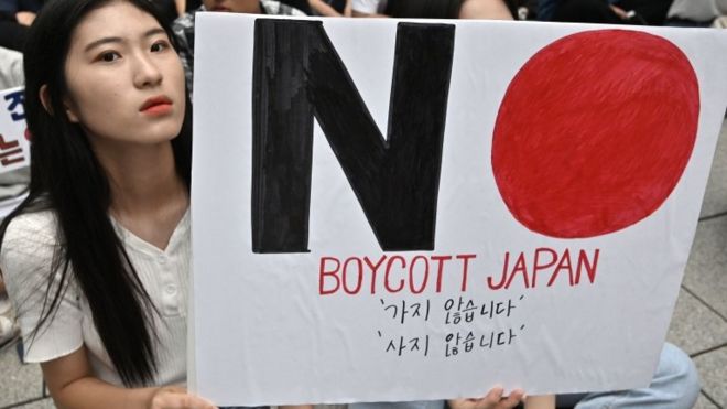 South Korean protesters hold a sign saying "Boycott Japan" in Seoul