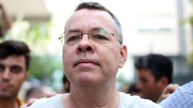 Pastor Andrew Craig Brunson is escorted by Turkish plainclothes police officers as he arrives at his house in Izmir, Turkey, 25 July 2018