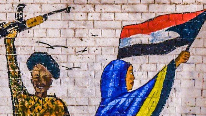 Граффити вооруженного сотрудника сил безопасности в Судане и протестующей женщины