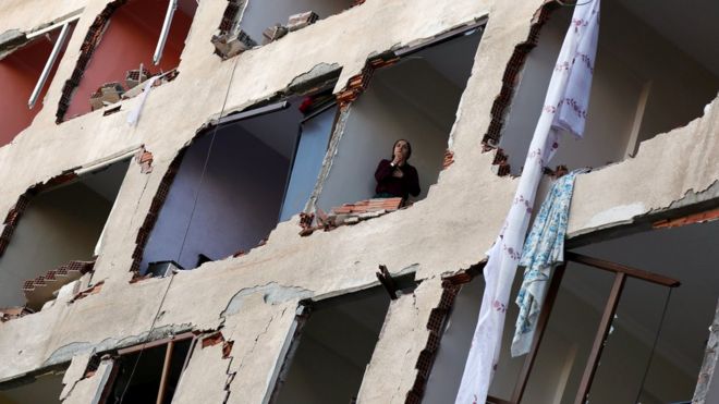 Женщина выходит из разрушенного здания в Диярбакыре, 4 ноября