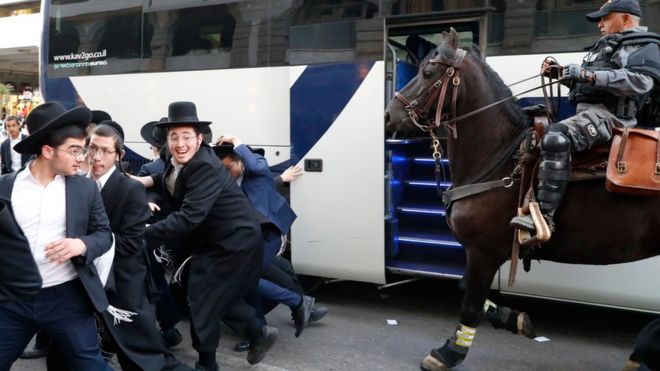 Конный израильский полицейский разгоняет группу ультраортодоксальных евреев во время демонстрации против призыва израильской армии в израильском городе Бней-Брак близ Тель-Авива 1 ноября 2019 года