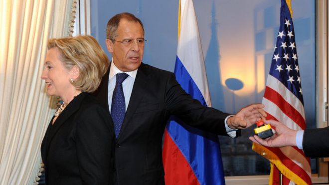 Руки госсекретаря США Хиллари Клинтон и министра иностранных дел России Сергея Лаврова лежат на красной кнопке с надписью «перезагрузка» на английском языке и «перегрузка» на русском языке