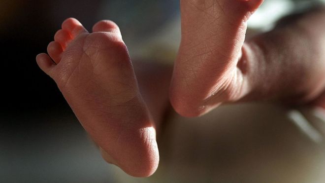 In this file photograph taken on March 20, 2007, a two-week-old boy finds his feet in his new world.