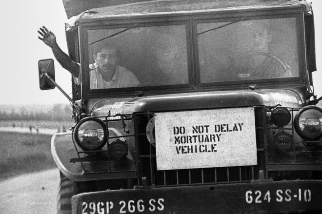 A sign on the front of a truck which reads 'do not delay mortuary vehicle'