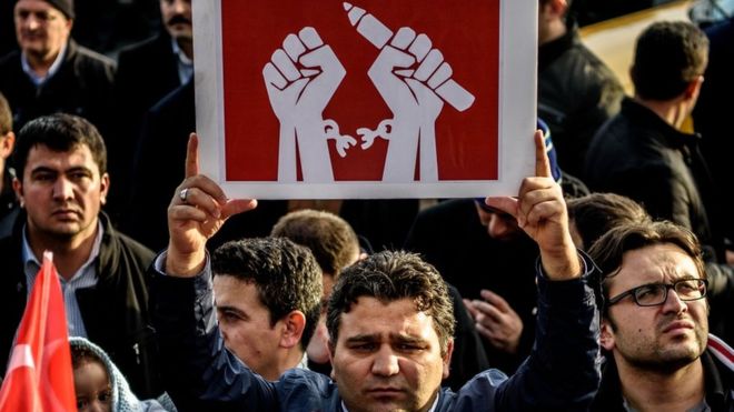 A man holds up a placard as people demonstrate in support of Turkish daily newspaper Zaman in Istanbul on 4 March 2016