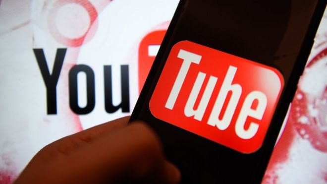 Логотип YouTube разделен между стеной и экраном телефона