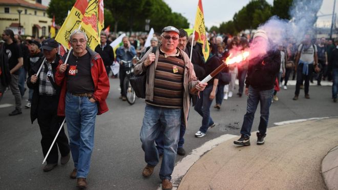 Демонстрант несет дорожную вспышку 26 мая 2016 года в Нант, западная Франция