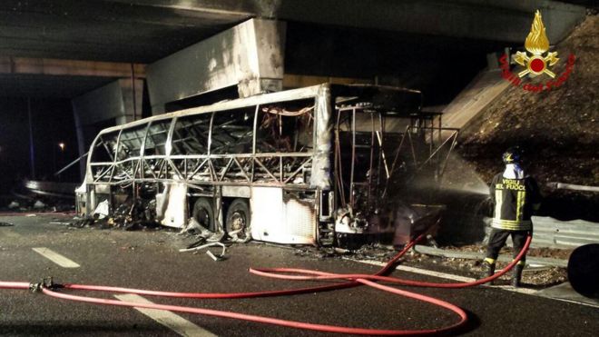 Bombero lanza agua al autobús que se incendió en Verona, Italia.