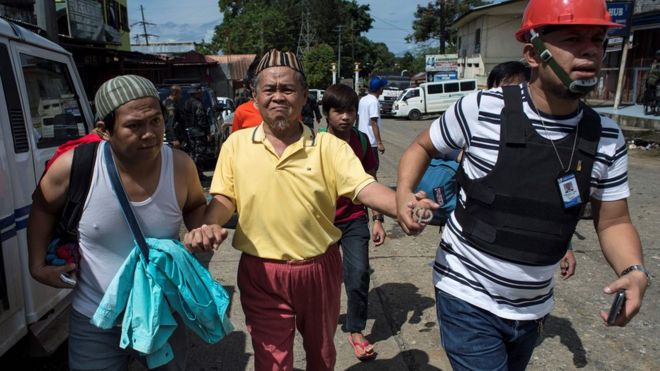 Evacuated residents arrive at a checkpoint in Marawi City on the southern island of Mindanao