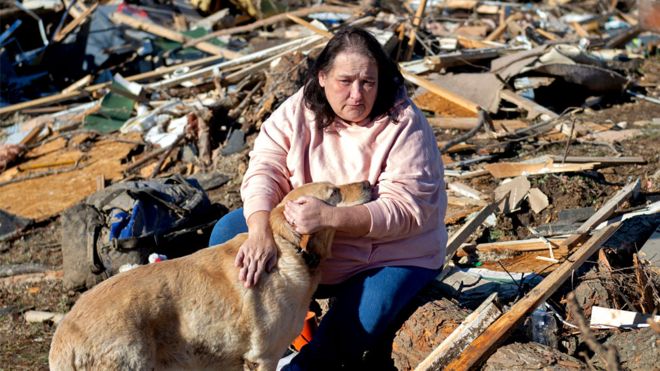 Charlene Stanley of Central City, Kentucky holds dog Gus as they search the debris that once was her sister-in-law's home after the tornado in Bremen, Kentucky, US, on 12 December 2021