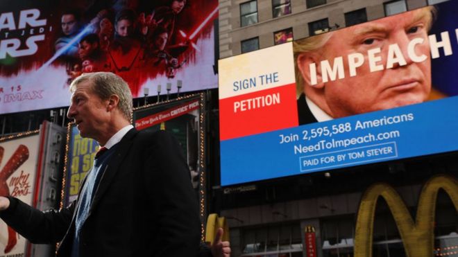 Филантроп Том Стейер стоит возле рекламного щита, рекламирующего его ходатайство об импичменте Дональда Трампа в Нью-Йорке.