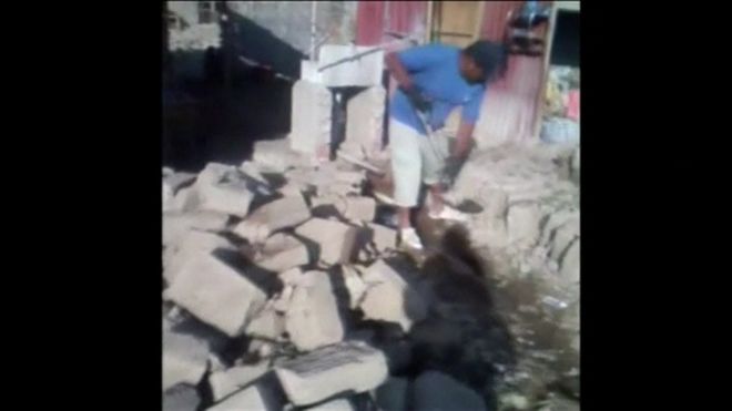 Man clearing rubble in Acari, Peru, following earthquake (14 January 2018)