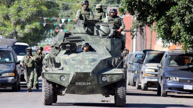 Солдаты патрулируют автомобиль на улице возле места преступления, где тело мужчины, которого, по словам свидетелей, сбросили с самолета, приземлилось на крыше больницы в Кулиакан, в северном штате Синалоа, Мексика 12 апреля 2017 г.