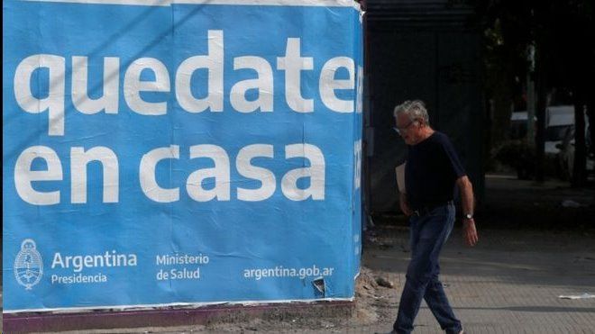 Homem passa diante de cartaz na Argentina