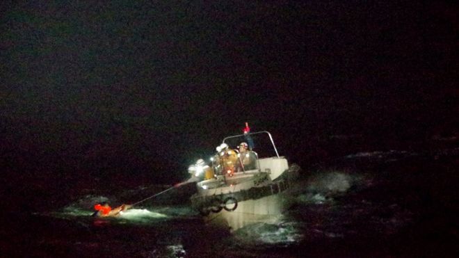Патрульный корабль вытаскивает моряка из воды