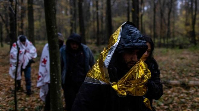 مهاجرون سوريون يسيرون عبر الغابة بالقرب من هاجنوكا، بولندا، خلال عملية إنقاذ لهم في 23 أكتوبر/تشرين الأول 2021