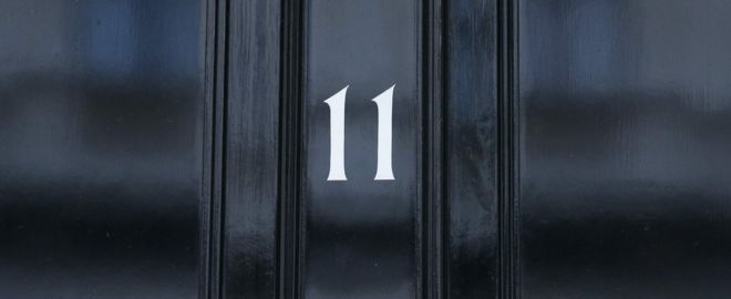 На изображении изображена входная дверь Даунинг-стрит, 11, официальной резиденции канцлера казначейства