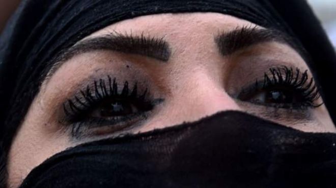 Mujer con los ojos pintados y burka.
