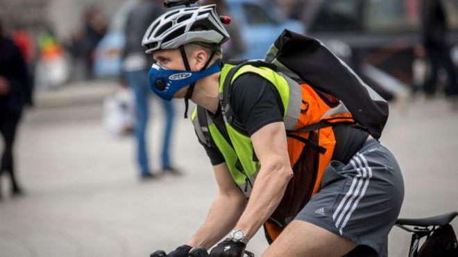Un ciclista con la cara cubierta con una máscara que filtra el aire