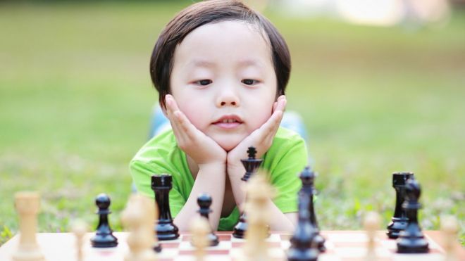 Niño con un tablero de ajedrez