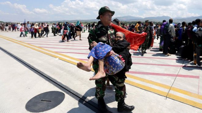 An Indonesian soldier carries an elderly woman evacuated after an earthquake and tsunami at Mutiara Sis Al Jufri airport in Palu, Central Sulawesi, Indonesia, October 1, 2018 in this photo taken by Antara Foto