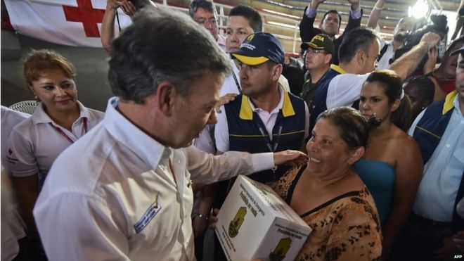 Президент Колумбии Хуан Мануэль Сантос (слева) приветствует женщину во время раздачи гуманитарной помощи в приюте в Кукуте 26 августа 2015 года