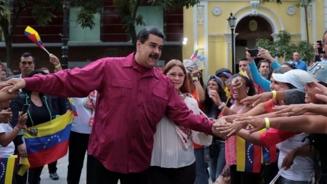 Президент Венесуэлы Николас Мадуро (С) приветствует сторонников, когда он прибывает на мероприятие с женщинами, рядом со своей женой Силией Флорес (в центре R), в Каракас, Венесуэла, 25 января 2018 года.