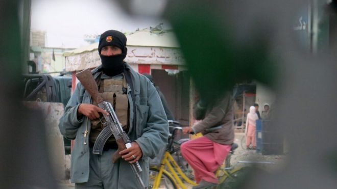 An Afghan security member secures the site after an attack on Police station in Kandahar