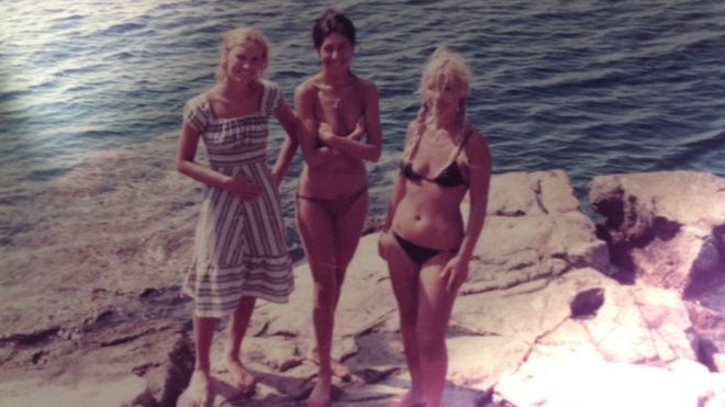 Дениз Хейс и ее двое друзей стоят на скале у моря в Гидре, Греция