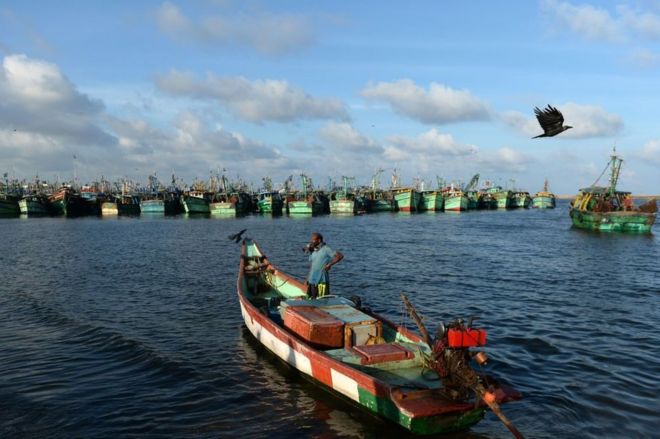 Индийский рыбак стоит на своей лодке после ночной работы на море в Ченнае 21 ноября 2017 года.