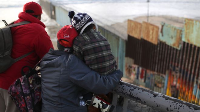 Members of the migrant caravan look over the U.S.-Mexico border fence on November 30, 2018 in Tijuana, Mexico