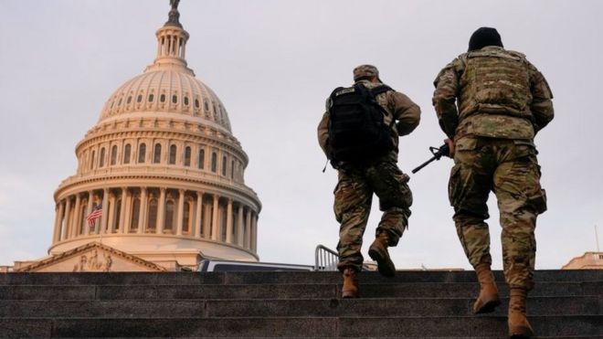 National Guard members walk at the Capitol in Washington on January 15, 2021