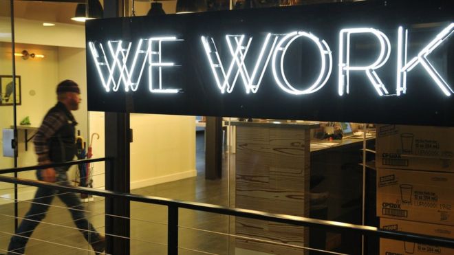 13 марта 2013 года в Вашингтоне, округ Колумбия, мужчина входит в двери кооперативного рабочего пространства WeWork.