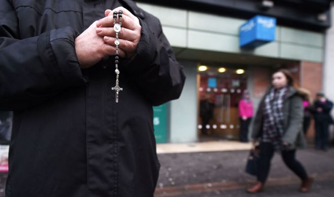 12 января 2016 года в Белфасте, Северная Ирландия, активист по борьбе с абортами молится своими четками возле клиники Мари Стопс.