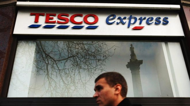 Человек проходит мимо Tesco Express