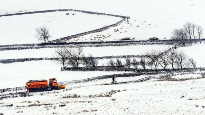 Человек гуляет со своей собакой по снегу в Мустоне, Лестершир